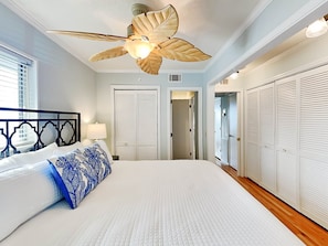Relax in a spacious bedroom with a large bed, ceiling fan, and closet.