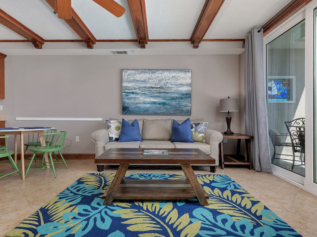 A living room with a sofa, coffee table, and a painting on the wall.