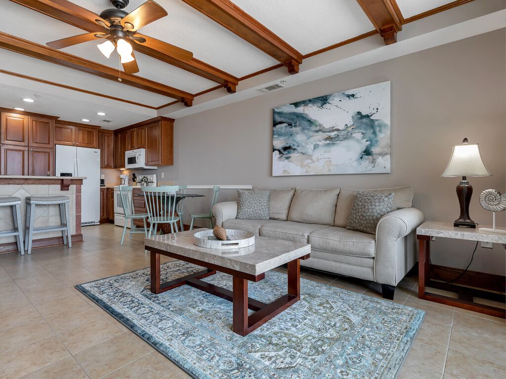 A spacious living area with a dining table, a sofa, and a kitchen in the background.