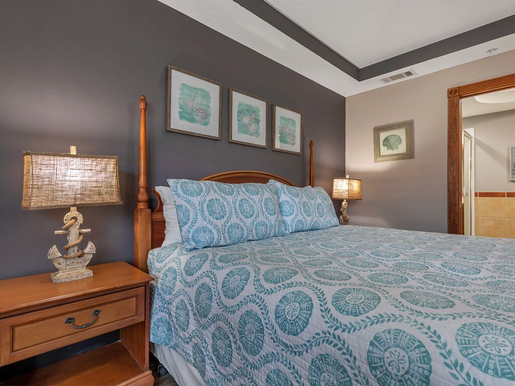 Un dormitorio con cama, mesita de noche y una obra de arte en la pared.