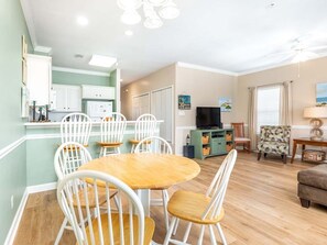 A compact living space with a dining area, kitchenette, and seating area. - Tybee Sands by Tybee Vacation Rentals (Tybee Island)
