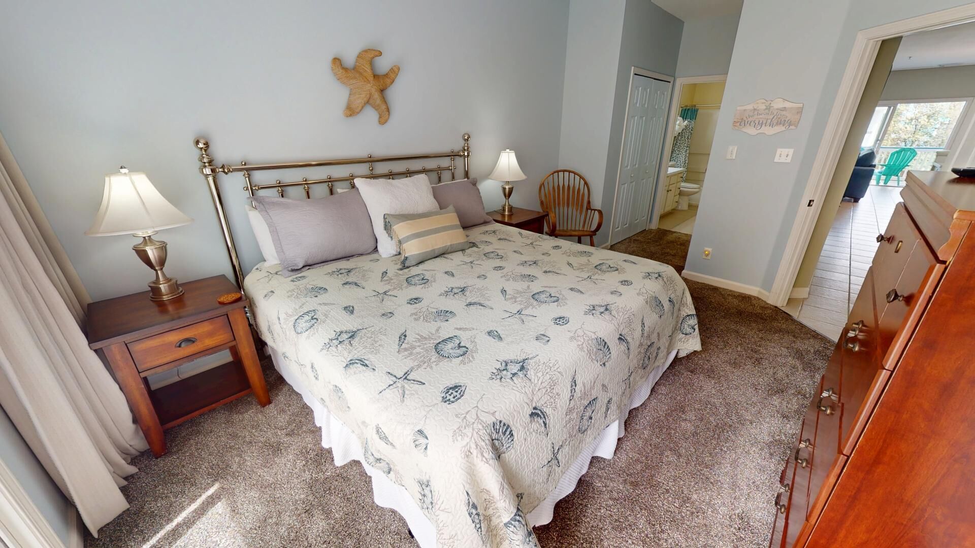 Un dormitorio con cama, mesitas de noche, una silla y un aparador.