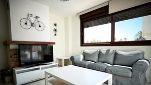 A modern living room with a television, sofa, and coffee table. - PUSHE Village Playa Granada Beach & Golf 3 (Motril)