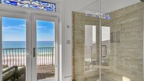 A glass-enclosed shower with a view of the beach and ocean. - Gulf Front With Private Pool- Emerald View on 30A by Royal Destinations (Santa Rosa Beach)