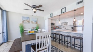 Una cocina moderna con armarios blancos, una isla central y taburetes de bar.
