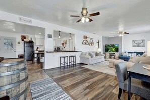 A spacious living area with a kitchen, dining area, and seating.