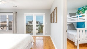 Ein Schlafzimmer mit großem Fenster, Balkon und Etagenbett.