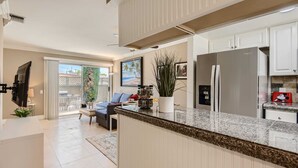 A modern kitchen with white cabinets, a granite countertop, and stainless steel appliances. - Spacious 3BR-  Yard - BBQ - Parking! (Costa Mesa)