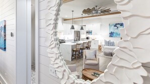 A modern kitchen with white cabinetry, a central island, pendant lighting, and a ceiling fan. - Big Wave by Tybee Vacation Rentals (Tybee Island)