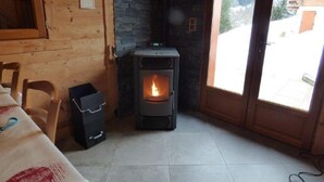 A room with a wood-burning stove, a window, and a door leading outside. - Ground floor, parking, tv, 62m², Arêches-Beaufort (Beaufort)