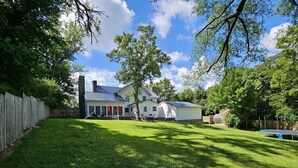 A house with a fenced backyard, a covered patio, and a trampoline.