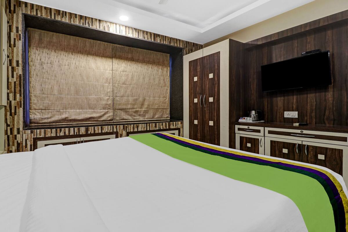 A hotel room with a bed, a television, and a wardrobe.