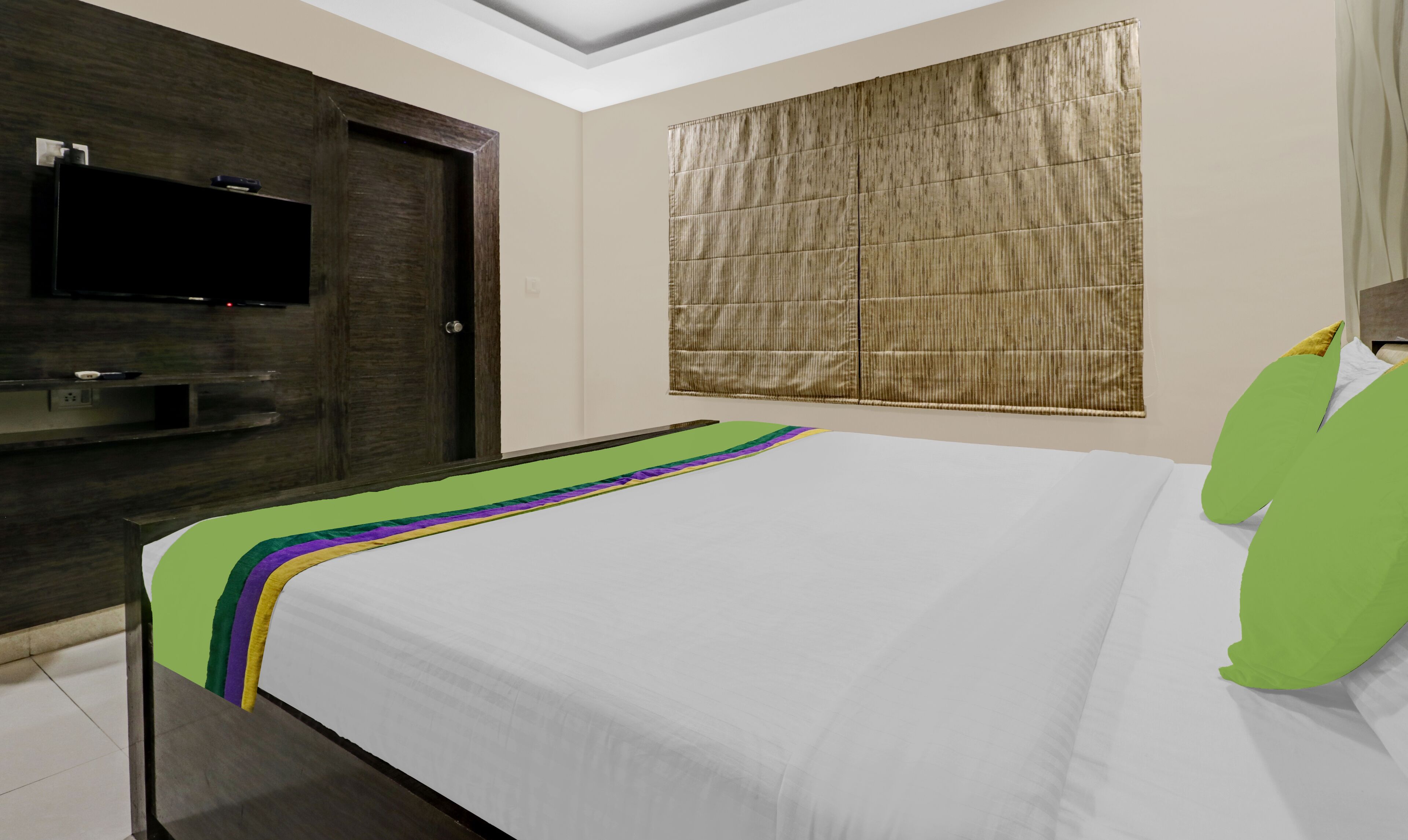 Een hotelkamer met een bed, een televisie op een houten kast en een raam met een bamboe zonwering.