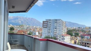Un balcon offrant une vue sur la ville et les montagnes.