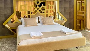 Une chambre d’hôtel moderne avec un grand lit, une tête de lit décorative et un plancher en bois.