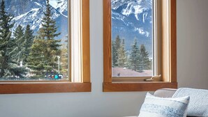 A room with two windows overlooking a mountainous landscape. - Bluebird - Spacious Luxury, Shared Rooftop Hot Tub (Canmore)