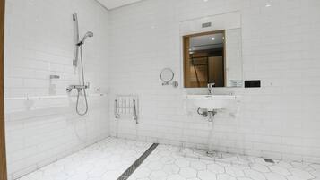 A modern bathroom with white hexagonal tiles, a shower, a sink, and a mirror.