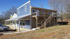A two-story house with a covered porch and a staircase leading to the upper floor. - 2 BR,1BA Spacious Mountain View Suite near Cherokee National Forest, Ocoee River (Benton)
