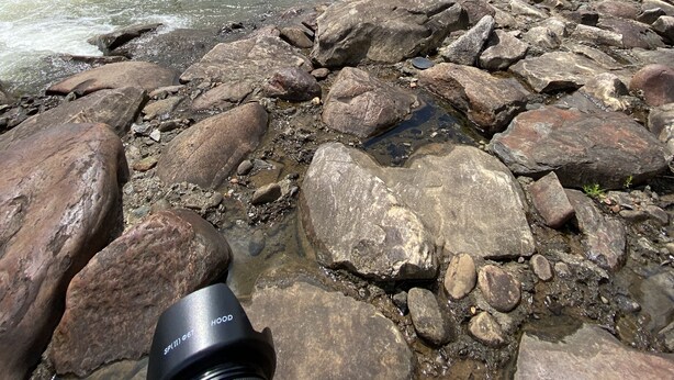 A rocky riverbank with a camera lens in the foreground. - 2 BR,1BA Spacious Mountain View Suite near Cherokee National Forest, Ocoee River (Benton)