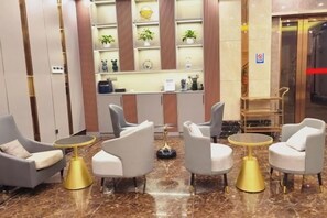Un vestíbulo con asientos, mostrador de recepción y una exhibición de plantas.