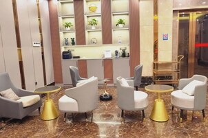 Un vestíbulo con asientos, mostrador de recepción y una exhibición de plantas.