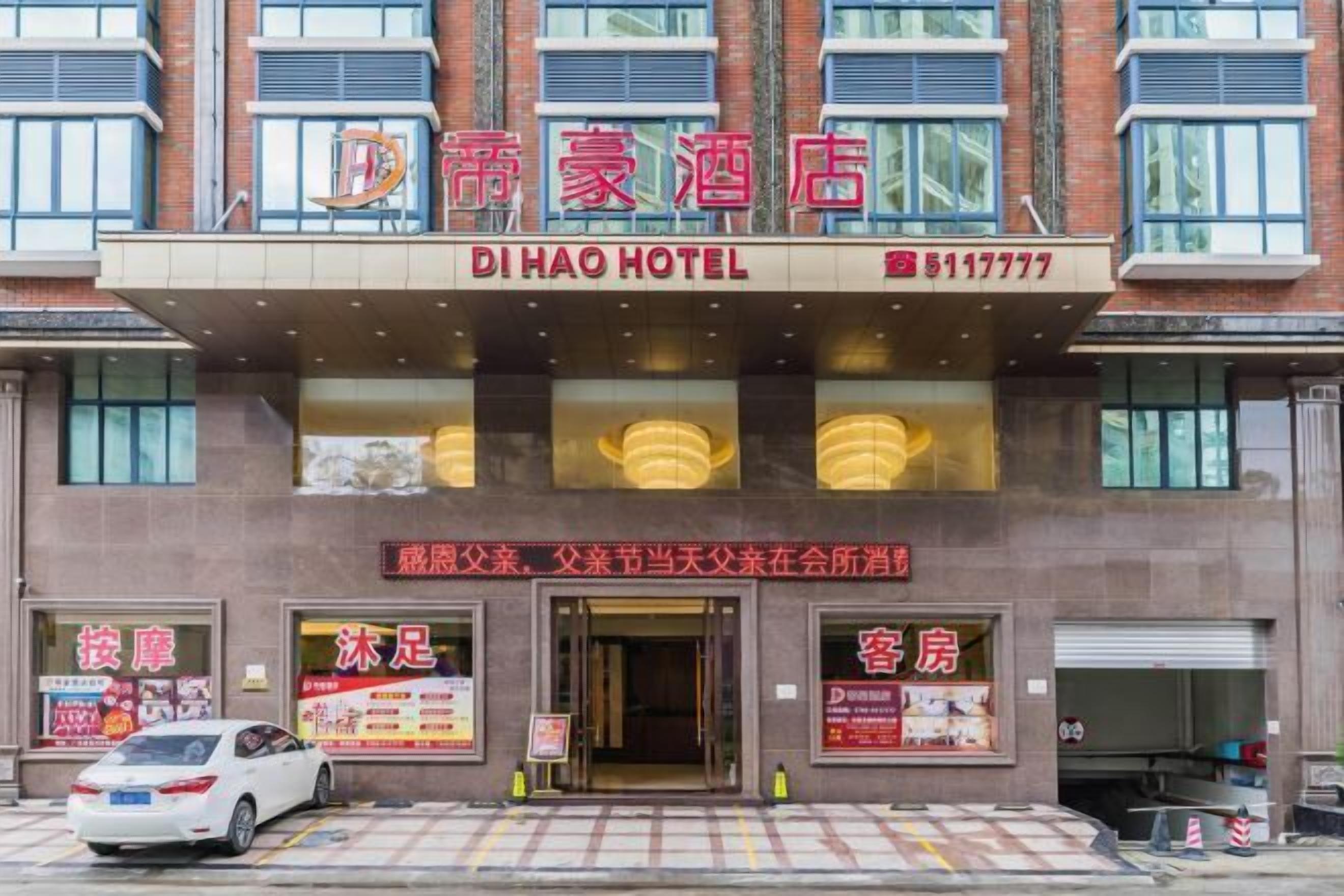 DI HAO HOTELs facade med et skilt, der viser hotellets navn og telefonnummer.