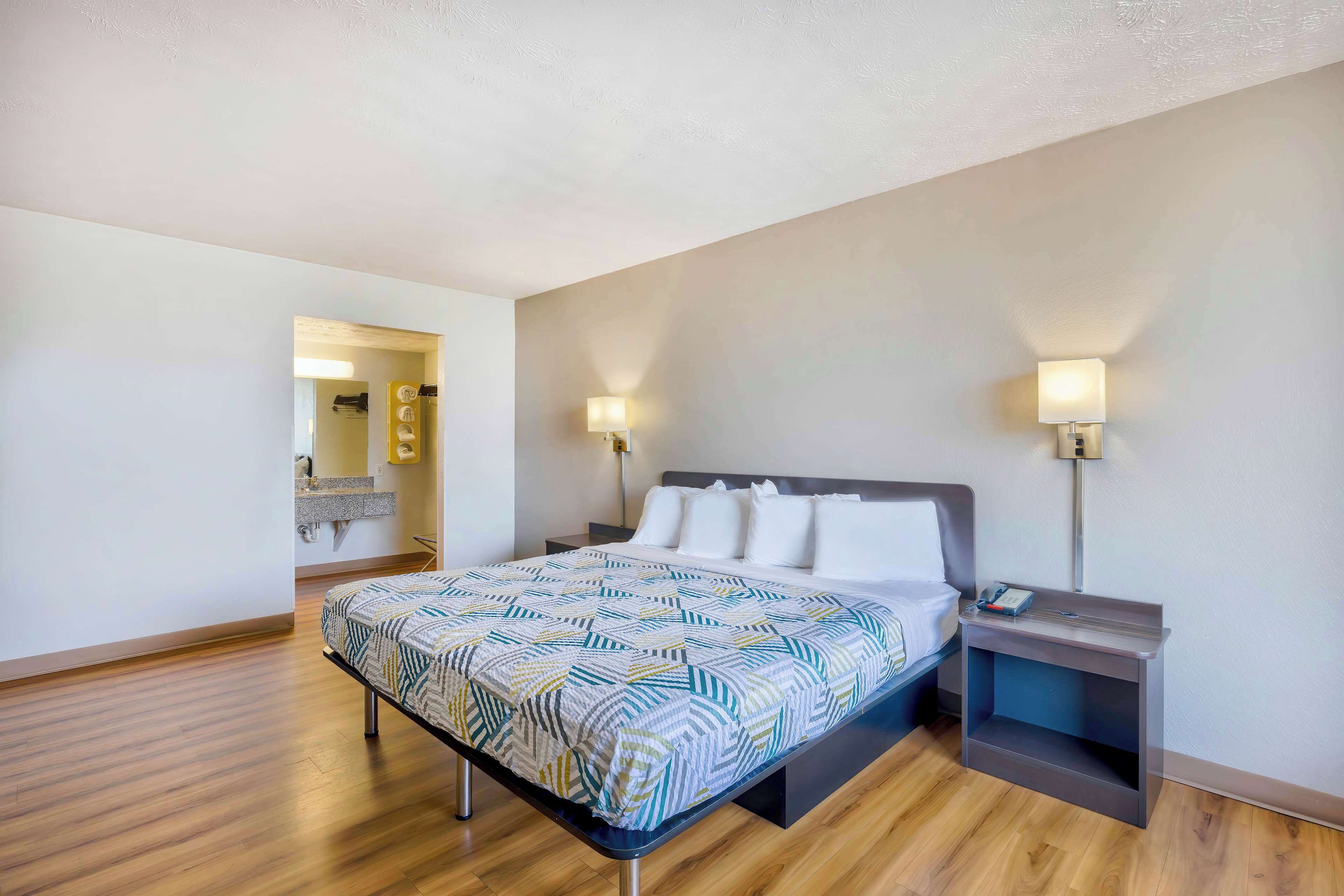 Ein Hotelzimmer mit Bett, Nachttischen und einem Beistelltisch.