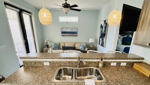 A kitchen with a double sink, granite countertops, and a ceiling fan. -  Bayside Cottage 4 miles to Destin, Shopping & Beaches, minutes to Elgin AFB (Niceville)