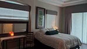 A bedroom with a bed, bedside table, chair, and a ceiling fan. - Luxury Bayview Wellness Retreat w/Pool, Salt-Water Jacuzzi, Hot Tub...+ more! (Bradenton)