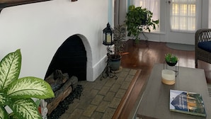 A room with a fireplace, a chandelier, and a bookshelf with decorative items. - Historical Natchitoches Home, close to downtown and Cane River. (Natchitoches)