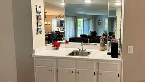 A kitchen with a white countertop, a sink, and a coffee bar sign on the wall. - Deluxe Golf Condo with Private, Covered Balcony - BEAUTIFUL View of the Ozarks (Branson)