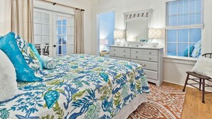 Une chambre à coucher avec un lit, une commode et une fenêtre.