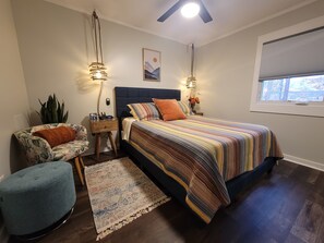 A bedroom with a bed, bedside tables, a ceiling fan, a window with blinds, and a potted plant. - Outdoorsman's Paradise at The Shady 180 - Lakeviews
Spa, Kayak, Golf, Hike, Fish (Waleska)