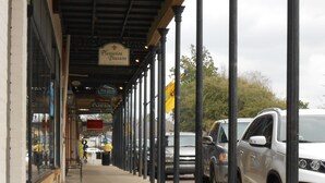 A covered outdoor area with a storefront named "Plantation Treasures" and a sign for "Cuban Cafe."