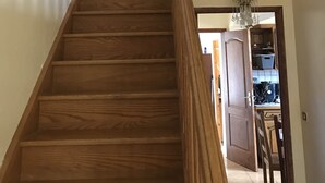 Una escalera de madera con un candelabro en la parte superior.