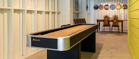 A pool table in a room with a white and yellow color scheme, a ceiling fan, and a wall with decorative plates.