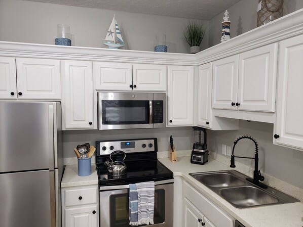 Enjoy cooking in this well-equipped kitchen with a refrigerator, microwave, oven, and stove.