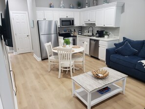 Cozy living area with a sofa, dining table, and kitchenette.