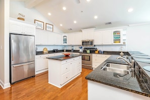 Enjoy cooking in this well-equipped kitchen with a central island, sink, and stainless steel appliances.