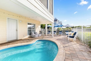 Relax by the pool surrounded by lounge chairs and umbrellas.