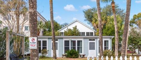 A house with a 'No Parking' sign, a swing set, and a 'Tybee Vacation Rentals' sign.