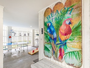Relax in a vibrant space with a tropical mural, desk, and whiteboard, perfect for work or play.