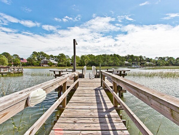 A wooden pier extending into a body of water with a clear sky above.
