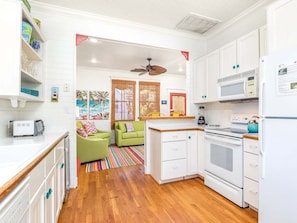 Kitchen area with white cabinetry, central island, and ample counter space.