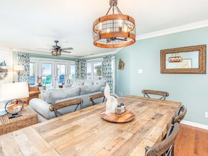 Enjoy meals in this stylish dining area with a table for four, a decorative centerpiece, and a ceiling fan.
