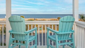 Two turquoise Adirondack chairs facing a beach with a clear view of the ocean. - Dolphin Watch 6 by Tybee Vacation Rentals (Tybee Island)