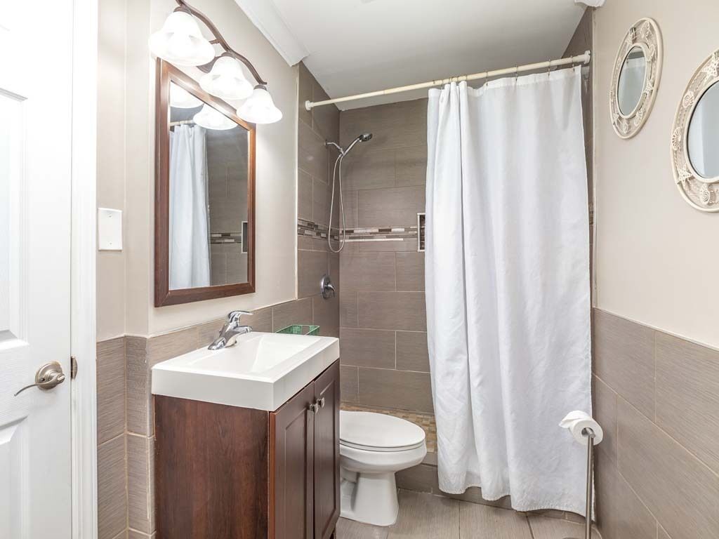 Une salle de bain avec douche, toilettes et lavabo.