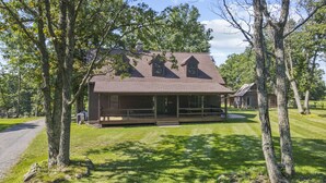 A rustic cabin with a porch, surrounded by trees and a well-maintained lawn. - Mountain View Cabin in VA Wine Country (Scottsville)