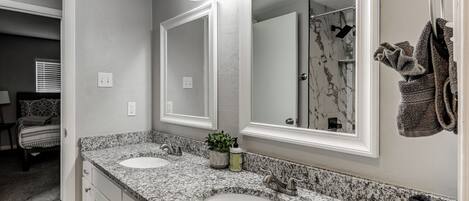 A bathroom with two sinks, a large mirror, and a towel rack.