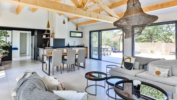 A modern living room with a sofa, coffee table, and dining area.